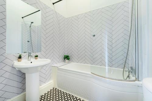 a white bathroom with a tub and a sink at 2 Bedroom in Center of London in London