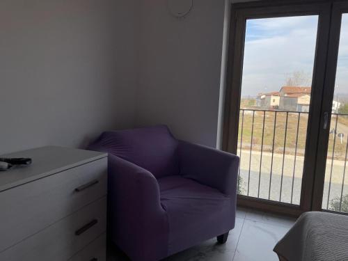 a purple chair in a room with a window at Le Ghie in Mondovì