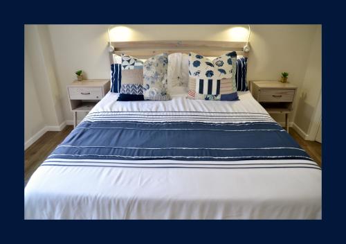 a large bed with blue and white sheets and pillows at Rest and Sea Self-catering - The perfect family or couples getaway to relax and refresh in Franskraal