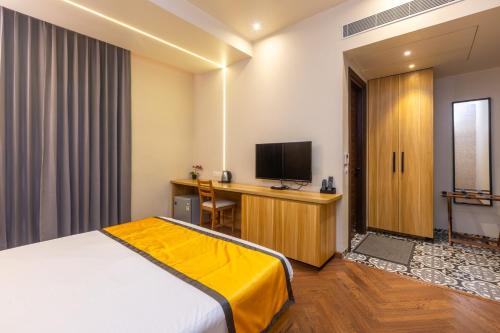 a hotel room with a bed and a desk with a television at Kohsa7 in Gurgaon