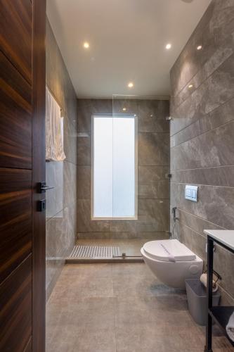 a bathroom with a toilet and a window at Kohsa7 in Gurgaon