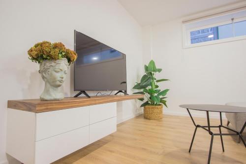 Cette chambre dispose d'une télévision, d'une table et d'un vase fleuri. dans l'établissement Mesão Frio by Guestify, à Guimarães