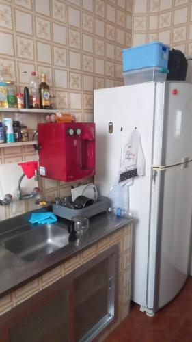 uma cozinha com um frigorífico branco ao lado de um lavatório em Quarto Casal próximo ao Sambódromo-RJ no Rio de Janeiro