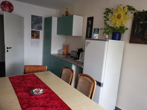 a kitchen with a table and a white refrigerator at TWS Pension an der B1 in Magdeburg
