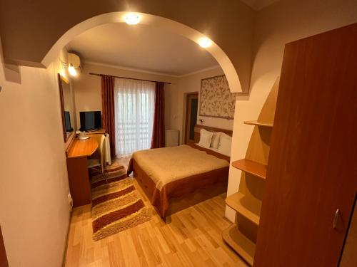 ein Schlafzimmer mit einem Bett und einem Schreibtisch in einem Zimmer in der Unterkunft Pensiunea Perla in Baile Felix