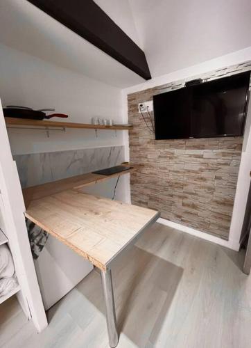 Cette chambre comprend une table et une télévision murale. dans l'établissement Cozy studio near Casino Monte-Carlo, à Beausoleil
