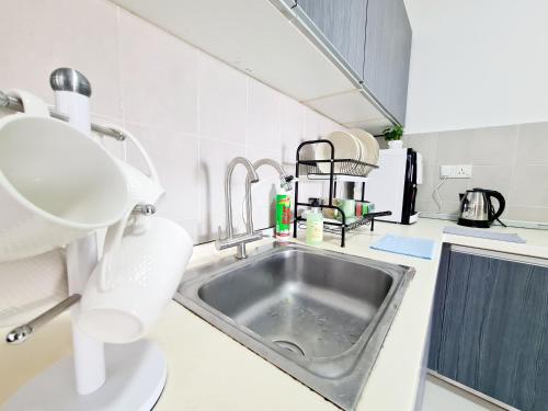 a kitchen with a sink and a white counter top at 11 Guest Comfy 3 Room Koi Kinrara Suite, IOI Puchong, Bukit Jalil Pavilion, Bukit Jalil Stadium, Sunway Pyramid, Sunway Lagoon in Kampong Baharu Sungai Way