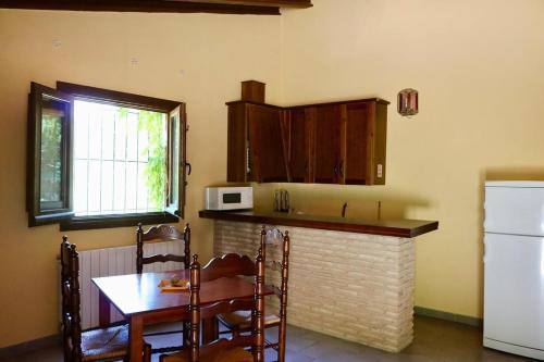 a kitchen with a counter and a table and a microwave at Casas Rurales Cortijo El Marqués in Quesada