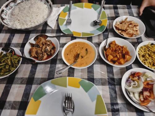 a table topped with plates of food on a table at Woodsy Villa in Sigiriya