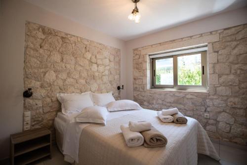 a bedroom with a bed with towels on it at Avesta Private Villas - Iokasti in Vlikhon