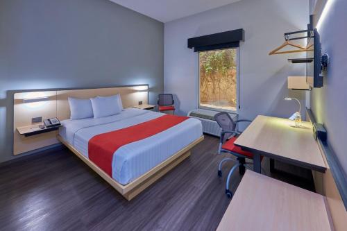 a hotel room with a bed and a desk at City Express by Marriott Ciudad Juárez in Ciudad Juárez