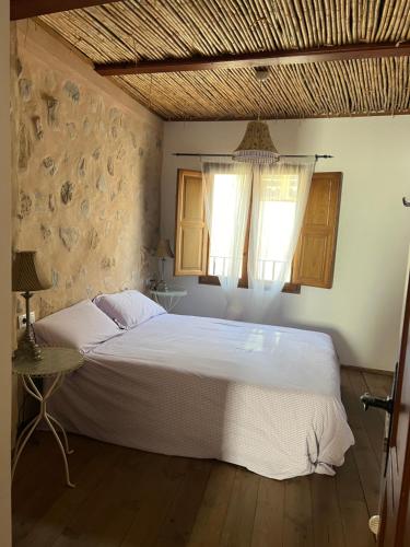 a bedroom with a white bed and a window at La Casita de Las Estrellas in Algimia de Almonacid