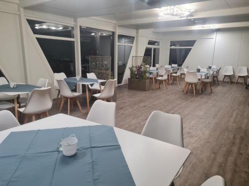 a dining room with tables and chairs and windows at Lins B&B Hotel Resort in Marktlustenau