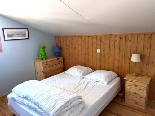 - une chambre avec un lit et une grenouille verte assise sur une commode dans l'établissement Chalet Bassin d'Arcachon Parc Résidentiel Loisirs, à La Teste-de-Buch
