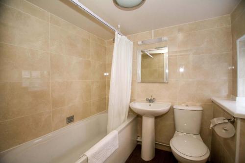 łazienka z toaletą, umywalką i wanną w obiekcie The Three Tuns Hotel Wetherspoon w mieście Thirsk
