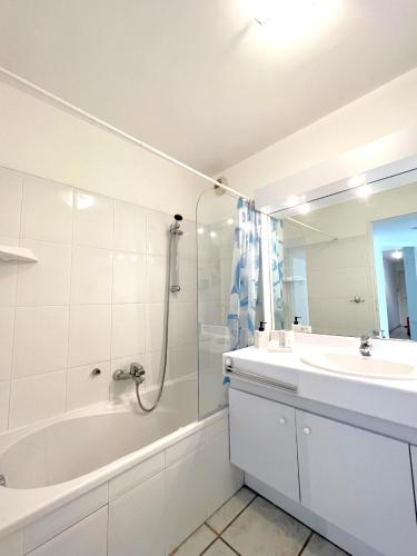 une salle de bain blanche avec une baignoire et un lavabo dans l'établissement Palazzio 3, quartier vieux port avec parking, by Welcome to Cannes, à Cannes