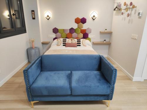 a blue couch in front of a bed in a room at Apartamentos Centro Oviedo Caveda in Oviedo