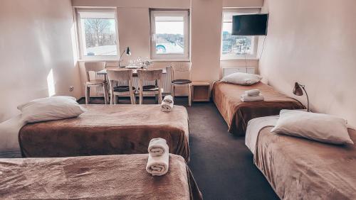 帕內韋日斯的住宿－佩瓦匝酒店，带三张床的房间和带桌子的用餐室