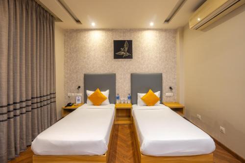 two beds in a hospital room with yellow pillows at Kohsa7 in Gurgaon