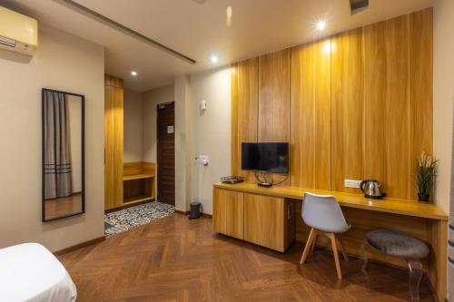 a bedroom with a desk with a tv and a chair at Kohsa7 in Gurgaon