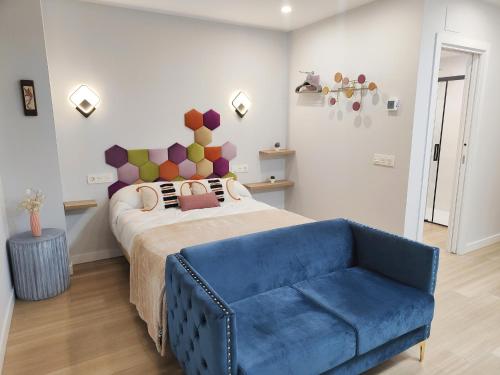 a bedroom with a bed and a blue couch at Apartamentos Centro Oviedo Caveda in Oviedo