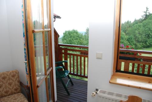 a room with a balcony with a chair and a window at Gasthof Diewald in Raach am Hochgebirge