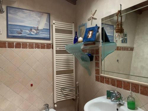 uma casa de banho com um lavatório e um espelho em Sotto le stelle delle balze em Castelfranco di Sopra