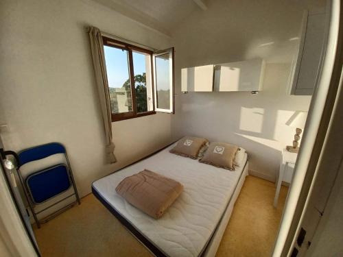 une petite chambre avec un lit et une fenêtre dans l'établissement Appart mezzanine avec balcon Piscine, à Saint-Cyprien