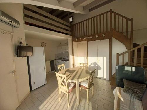une cuisine et une salle à manger avec une table et des chaises dans l'établissement Appart mezzanine avec balcon Piscine, à Saint-Cyprien