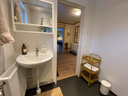 a bathroom with a white sink and a hallway at Per-Sims in Ljusdal