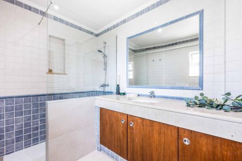 ein Bad mit einem Waschbecken und einem Spiegel in der Unterkunft Villa Tamara in Olhos de Água