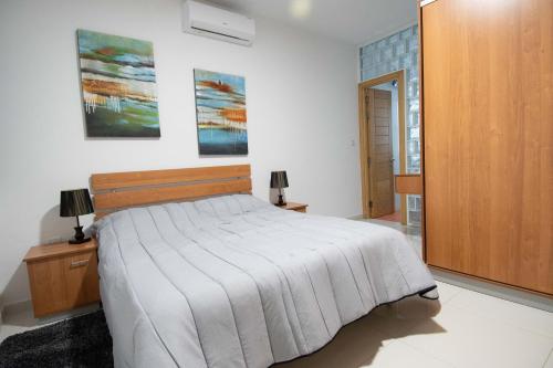 um quarto com uma cama e um armário de madeira em Venus Apartment em Sliema