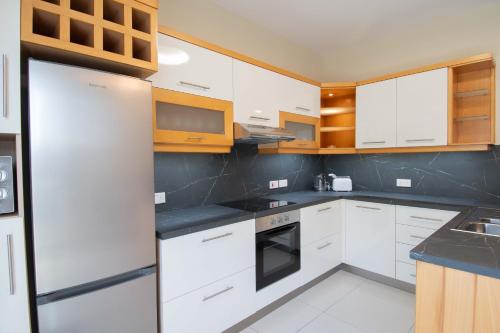 uma cozinha com armários brancos e um frigorífico em Venus Apartment em Sliema