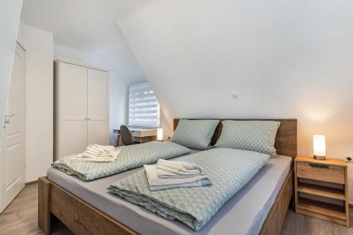 1 dormitorio con 1 cama con 2 toallas en Ferienhaus Burghalde mit Sauna, en Alpirsbach