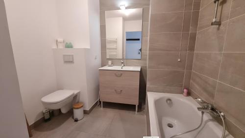 a bathroom with a tub and a sink and a toilet at FRGK "Charme alpin et confort moderne" in Saint-Étienne-de-Tinée