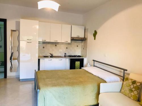 1 dormitorio pequeño con 1 cama y cocina en Pizzo Beach Studios Apartments, en Pizzo