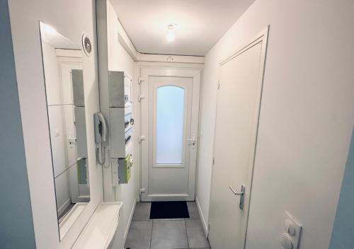 une salle de bain avec une porte et un couloir avec un miroir dans l'établissement Studio Lille stylé avec WiFi, terrasse, proche gares, à Lille