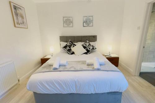 a bedroom with a large bed with two night stands at New King-size bed en-suit, luxury refurbished home in Newark-on-Trent