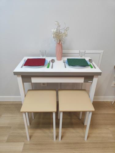 a white table with two chairs and a vase on it at Apartamentos Centro Oviedo Caveda in Oviedo