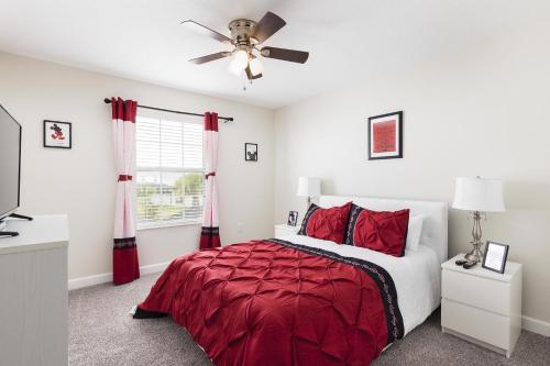- une chambre avec un lit rouge et un ventilateur de plafond dans l'établissement Top Villas - Championsgate 2140, à Davenport