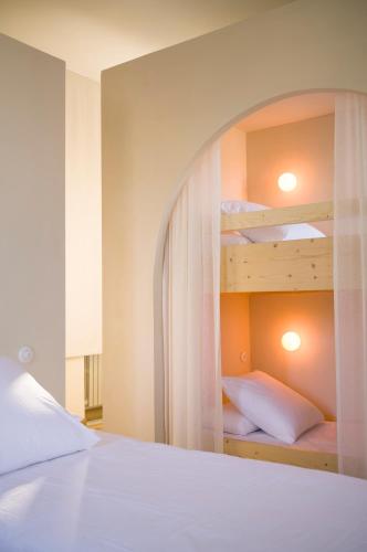 a bedroom with two bunk beds with white sheets at Maison La Grande Ourse in Beaucens