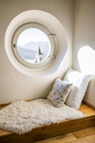 a circular window in a small room with a rug at Maison La Grande Ourse in Beaucens