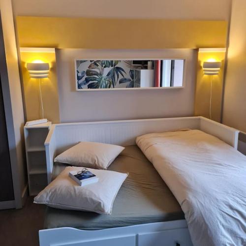 - une chambre avec un lit et un livre dans l'établissement A 2 pas de la plage de Perros : 2 à 4 hôtes., à Perros-Guirec