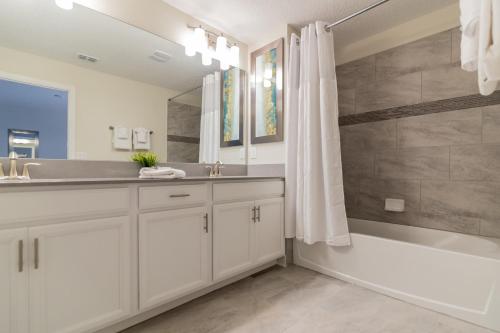 La salle de bains est pourvue d'un lavabo, d'une baignoire et d'une douche. dans l'établissement Top Villas - Championsgate 2141, à Davenport