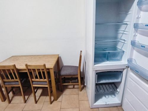 a kitchen with a table and chairs and an open refrigerator at Apartmány Pražská in Ústí nad Labem