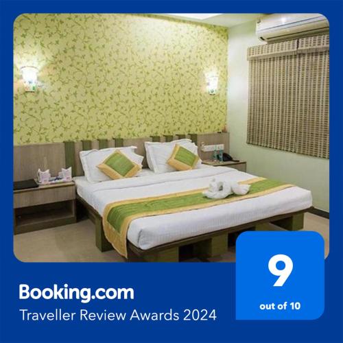 a hotel room with a bed with a towel on it at Vora Corporate Inn in Nagpur