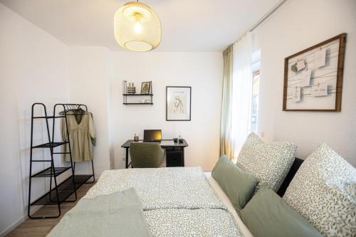 a living room with a couch and a desk at Bloßfeld-Apartments Geräumige Stadtoase mitten im Zentrum mit 3 Schlafzimmern, Gratis Parkplatz, W-Lan, Netflix in Jena