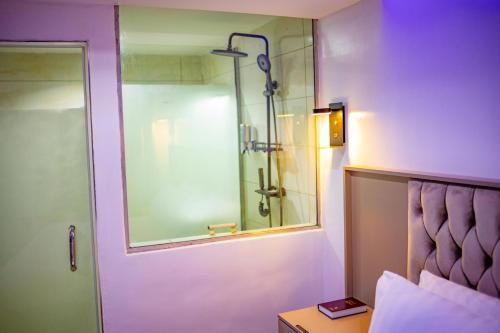 a bathroom with a shower and a glass door at WELLINGTON HOTEL LIMITED in Effurun