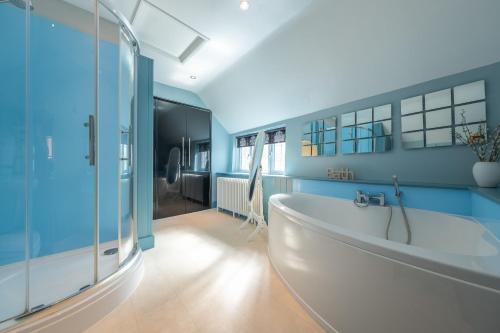 a bathroom with a tub and a glass shower at Cheney Hollow in Heacham