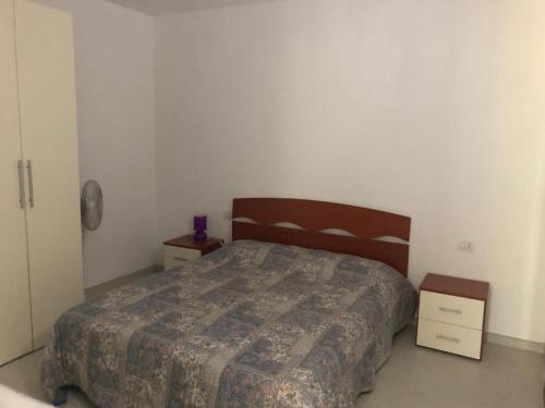 a bedroom with a bed and two night stands at Casa Vacanza Budoni Mare in Budoni